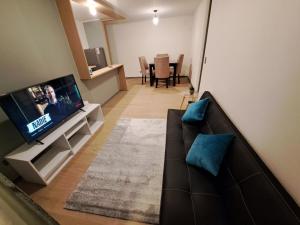 sala de estar con sofá y TV de pantalla plana en Departamento del norte, en Arica