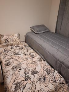 Dormitorio con cama con manta y almohada en Departamento del norte, en Arica