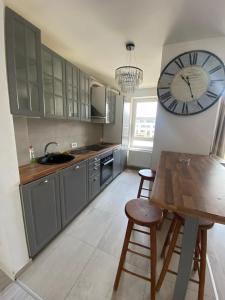 een keuken met een klok aan de muur en een tafel bij Royal Apartament in Braşov