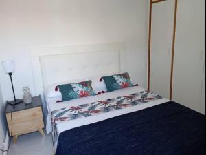 Casa en Castelldefels a 5 min de la playa في كاستيلديفِيلس: غرفة نوم مع سرير و منضدة مع سيد السرير
