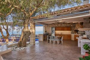 an outdoor kitchen and dining area with a tree at Jessica Luxury Villa in Agios Nikolaos
