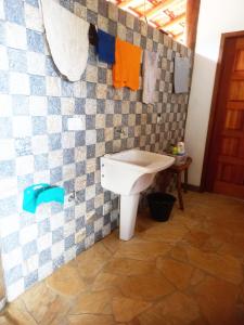 a bathroom with a toilet and a tiled wall at Country House - Ubatumirim Beach in Ubatuba
