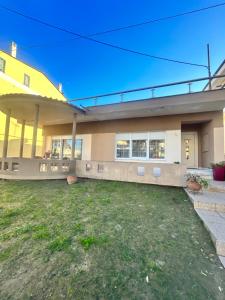 a large yellow house with a yard in front of it at Despina's House in Chrysoupolis