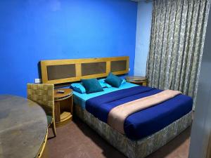 a bedroom with a large bed with blue walls at Conord Hotel - "Amman's Heart" in Amman