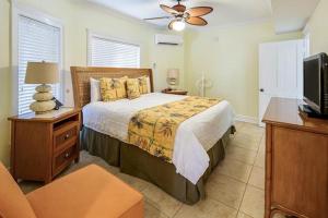 a bedroom with a bed and a flat screen tv at Coconut Beach Resort in Key West