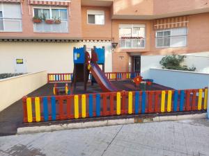 a playground with a slide in front of a building at Apartamento CentroLinares Con Parking in Linares