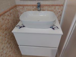 a white sink sitting on top of a white cabinet at Apartamento CentroLinares Con Parking in Linares