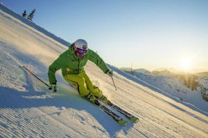 a man is skiing down a snow covered slope at Hotel Krvavec in Cerklje na Gorenjskem