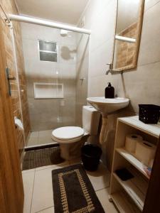a bathroom with a shower and a toilet and a sink at kitnet Praia do Morro Guarapari in Guarapari
