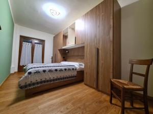 a bedroom with two beds and a chair in it at La Villetta di Oulx in Oulx