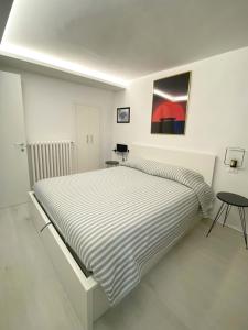 a white bedroom with a large bed and a table at PianoB&b in Campobasso
