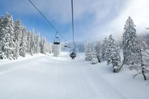 un impianto di risalita che sale su una pista innevata di Hotel Krvavec a Cerklje na Gorenjskem