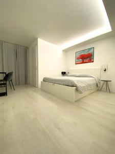 a white bedroom with a bed and a table at PianoB&b in Campobasso