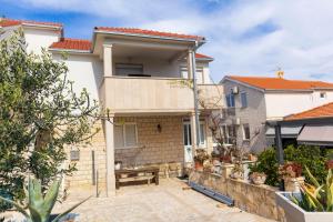 ein Haus mit einer Terrasse davor in der Unterkunft Apartments Ivanka in Supetar