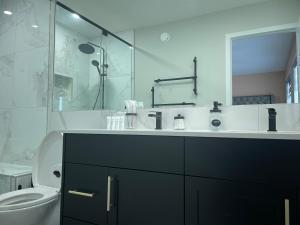 y baño con lavabo, aseo y ducha. en Beautiful 3 bedroom home, en Calgary