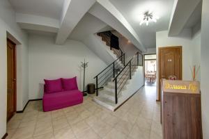 a living room with a purple couch and stairs at Dolyna Gir in Bukovel
