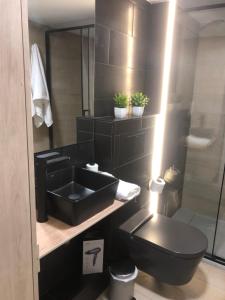 a black bathroom with a sink and a toilet at Loft 5 Maracena centro in Maracena