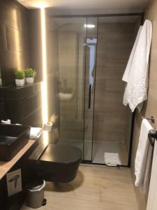 a bathroom with a black toilet and a shower at Loft 5 Maracena centro in Maracena