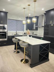 cocina con armarios negros y encimera blanca en Beautiful 3 bedroom home, en Calgary