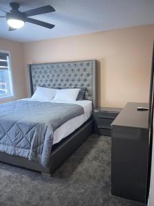 1 dormitorio con 1 cama grande y ventilador de techo en Beautiful 3 bedroom home, en Calgary