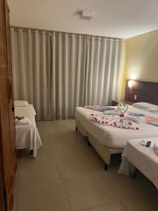 Habitación de hotel con 2 camas y cortinas en Sol e Mar - AP 05 - Be Summer en Flecheiras