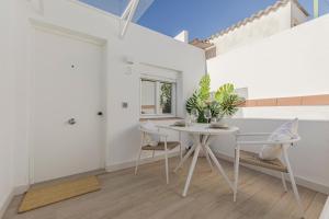 ein weißes Esszimmer mit einem Tisch und Stühlen in der Unterkunft Indulge Faustino 45-3 in Sevilla