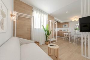 ein Wohnzimmer mit einem weißen Sofa und einem Tisch in der Unterkunft Indulge Faustino 45-3 in Sevilla