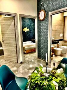 Cette chambre comprend une table avec des plantes et une horloge. dans l'établissement LAVIKA - Luxury Holiday Home, à Aci Trezza