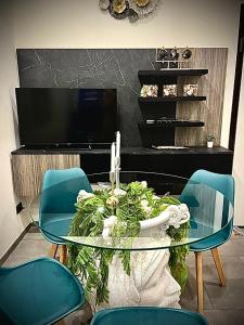 une salle à manger avec une table en verre et des chaises bleues dans l'établissement LAVIKA - Luxury Holiday Home, à Aci Trezza