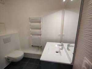 a bathroom with a sink and a toilet and a mirror at Le clos d'Asnières in Asnières-sur-Seine