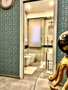 La salle de bains est pourvue de toilettes et d'une douche en verre. dans l'établissement LAVIKA - Luxury Holiday Home, à Aci Trezza