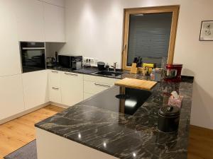 a kitchen with white cabinets and a black counter top at Anwesen mit Charme in Koblach