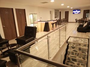 Hotel Palo Grande في مانيزاليس: غرفة انتظار وكراسي سوداء وطاولة