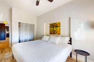 a bedroom with a white bed with a painting on the wall at Naples Hideaway in Marco Island