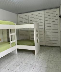 a bedroom with two bunk beds in a room at Aconchegante casa a 50m da praia in Praia Grande