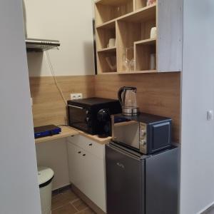 a small kitchen with a microwave and a refrigerator at Apartment B45 Borovets Gardans in Borovets
