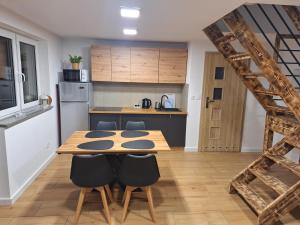a kitchen with a wooden table and some chairs at Domki przy Skarpie in Lądek-Zdrój +19 photos