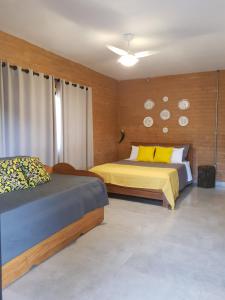 1 dormitorio con 2 camas y relojes en la pared en Pousada Fazenda Vitoria en São João Batista do Glória