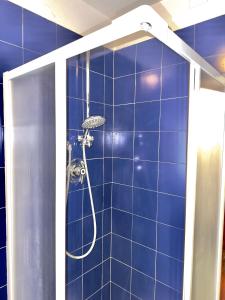 a shower in a bathroom with a blue tile wall at Villa Esclusiva a 3 Piani in Bardonecchia