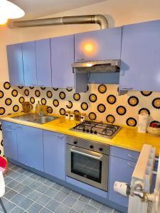 a blue kitchen with a stove and a sink at Villa Esclusiva a 3 Piani in Bardonecchia