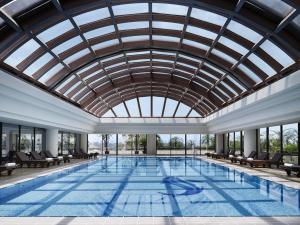 a large swimming pool with a glass ceiling at Pan Pacific Hanoi in Hanoi
