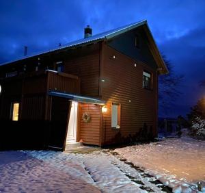 uma casa com uma porta iluminada na neve em Das Hexenlandhaus em Braunlage