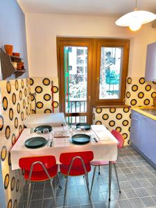 a kitchen with a table with four red chairs at Villa Esclusiva a 3 Piani in Bardonecchia