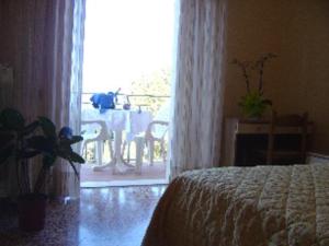 a bedroom with a bed and a table and a window at Hotel Rosa Del Tirreno in Quercianella
