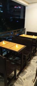 Hotel Palo Grande في مانيزاليس: طاولتين خشبتين مع أضواء عليهم على شرفة