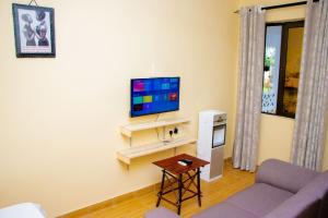 a living room with a couch and a tv at Vibrant Haven ~ Deux in Kilifi