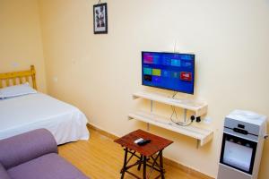 a room with a bed and a tv and a couch at Vibrant Haven ~ Deux in Kilifi
