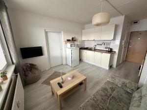 a living room with a table and a kitchen at Apartmán Kovářská u Klínovce in Kovářská