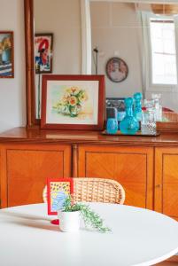 a dining room table with a picture on a cabinet at Dinoulas Penthouse: Renovated Apt in the City Center in Athens