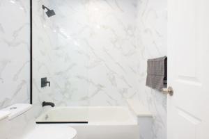a white bathroom with a sink and a toilet at New Modern Studio UES W D in New York